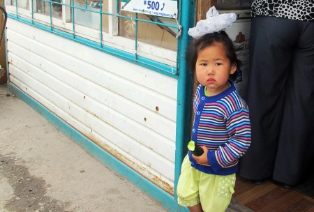 KIRGUISTAN 215 (EL LAGO ISSYK KUL) LA CIUDAD DE BALYKCHY, UNA CRIA KIRGUI COMIENDOSE UN PEPINO