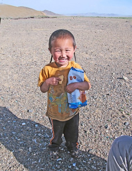 MONGOLIA 272 (HACIA UVURKHUSHUUT) …PERO NO LE BASTABA CON UNA Y A CONSEGUIDO EL PAQUETE (OBSERVAR LAS FINAS TRENZAS QUE LLEVA EL CRIO EN LA CABEZA)