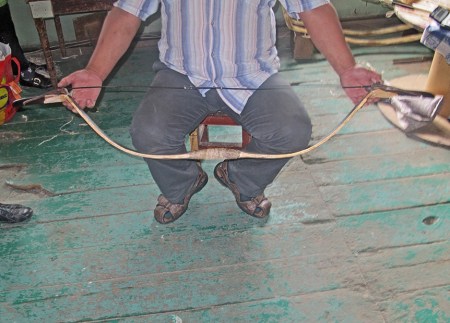 MONGOLIA 538 (LA POBLACION DE LOS ARCOS, DULAANKHAAN) EL SR. BOLBAATAR EXPLICANDO COMO SE MONTA LA CUERDA DEL ARCO, ESTE PUEDE LANZAR LA FLECHA UNA DISTANCIA DE MAS 500 M.