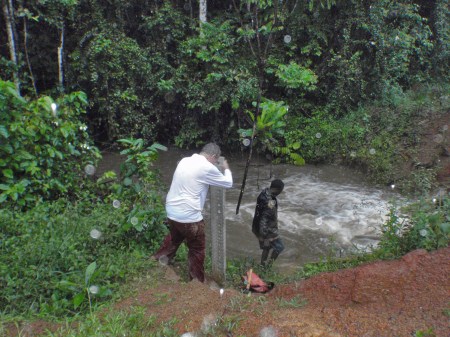 GABON 37. (DE MANDJI HACIA LOANGO) LAVANDO LAS PLANCHAS DE ARENA AYUDADO POR EL AUTOESPISTA EN UN RICHUELO, NO PARA DE LLOVER, AUNQUE EL AGUA CAE CALIENTE